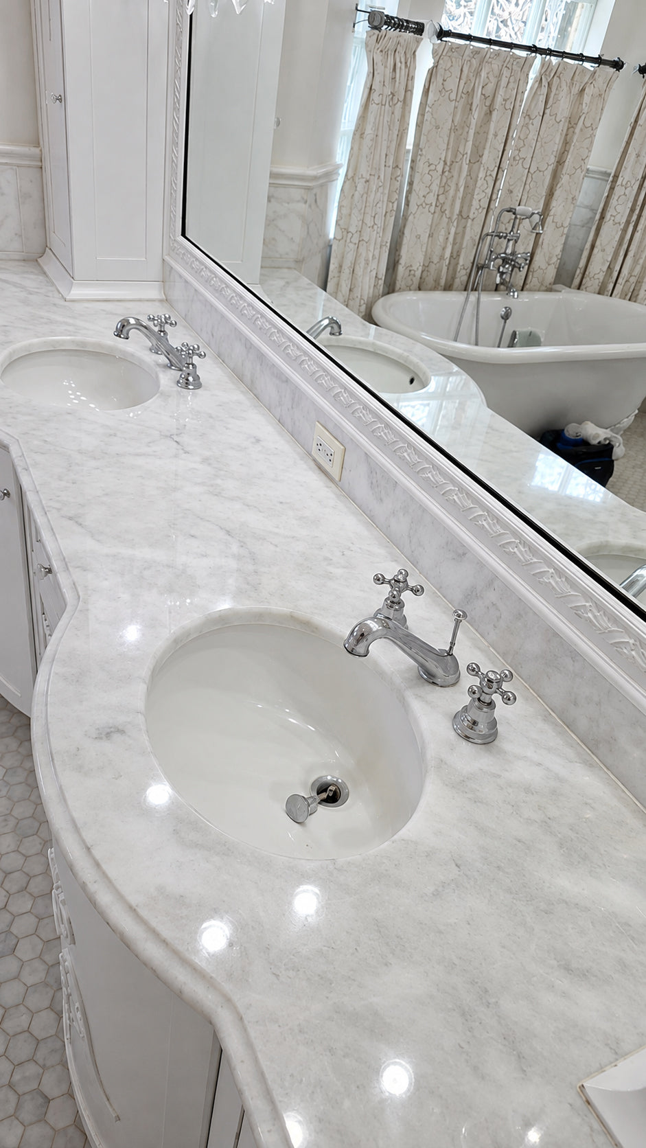 Restored double-sink white marble bathroom vanity with a clean polished finish and clear surface reflections.