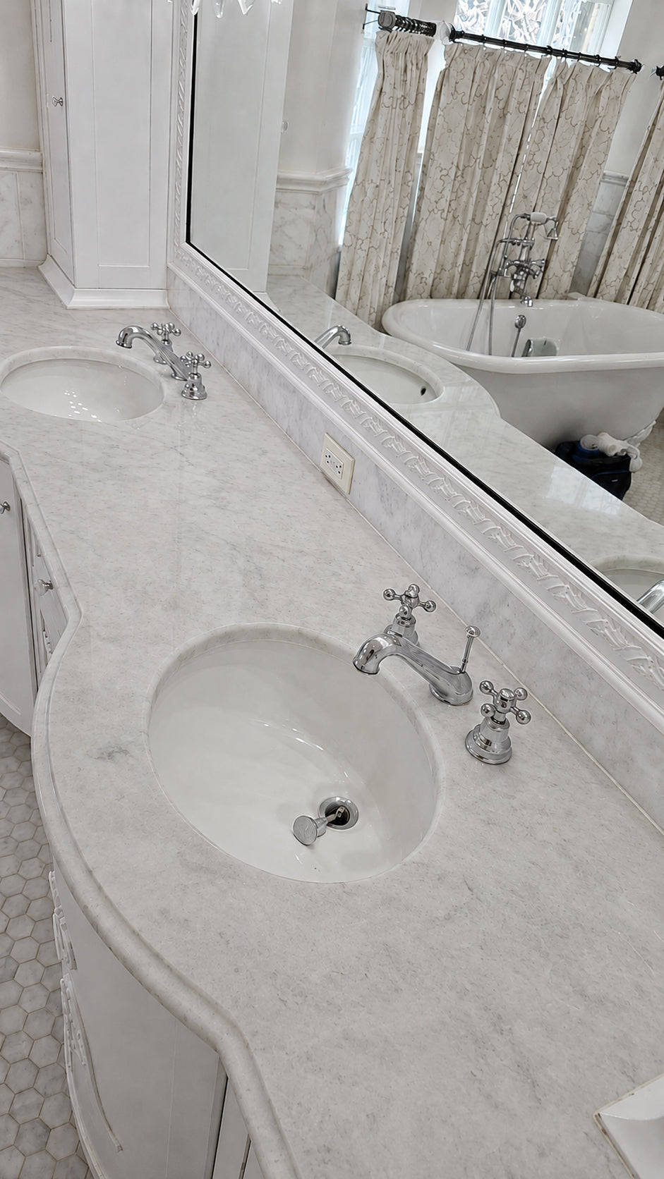 Double-sink white marble bathroom vanity prepared for polishing, with the mirror and fixtures protected.