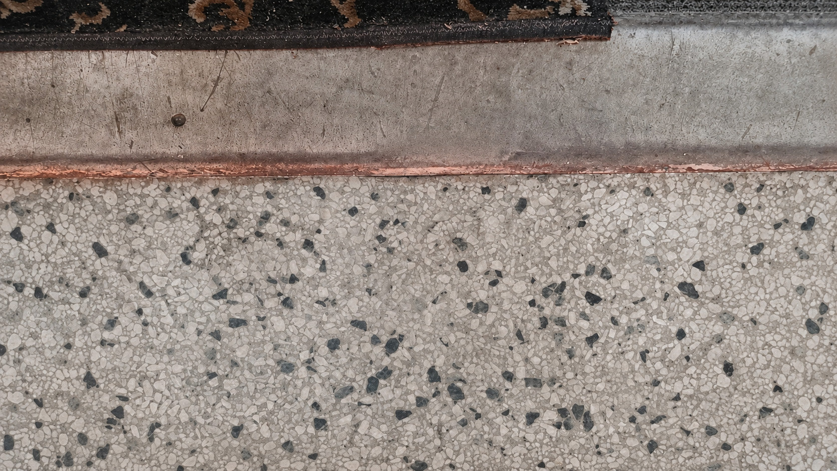 Repaired terrazzo floor with the damaged area blended into the surrounding surface.
