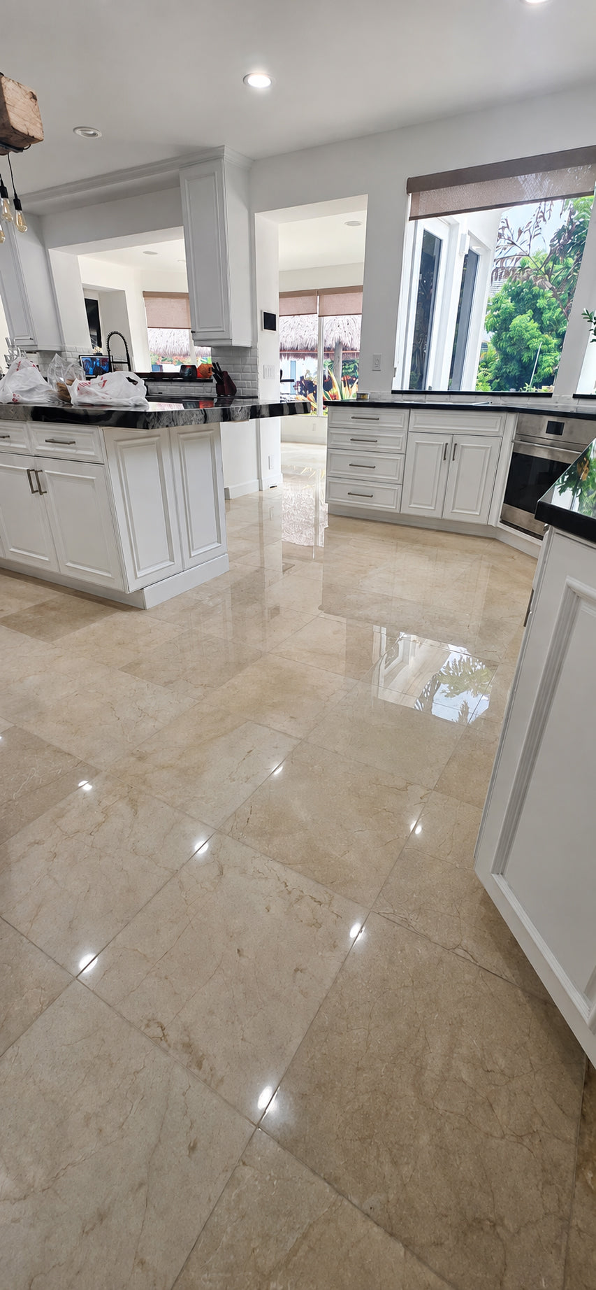 Restored cream marble tile kitchen floor with an even polished finish and clear surface reflections.